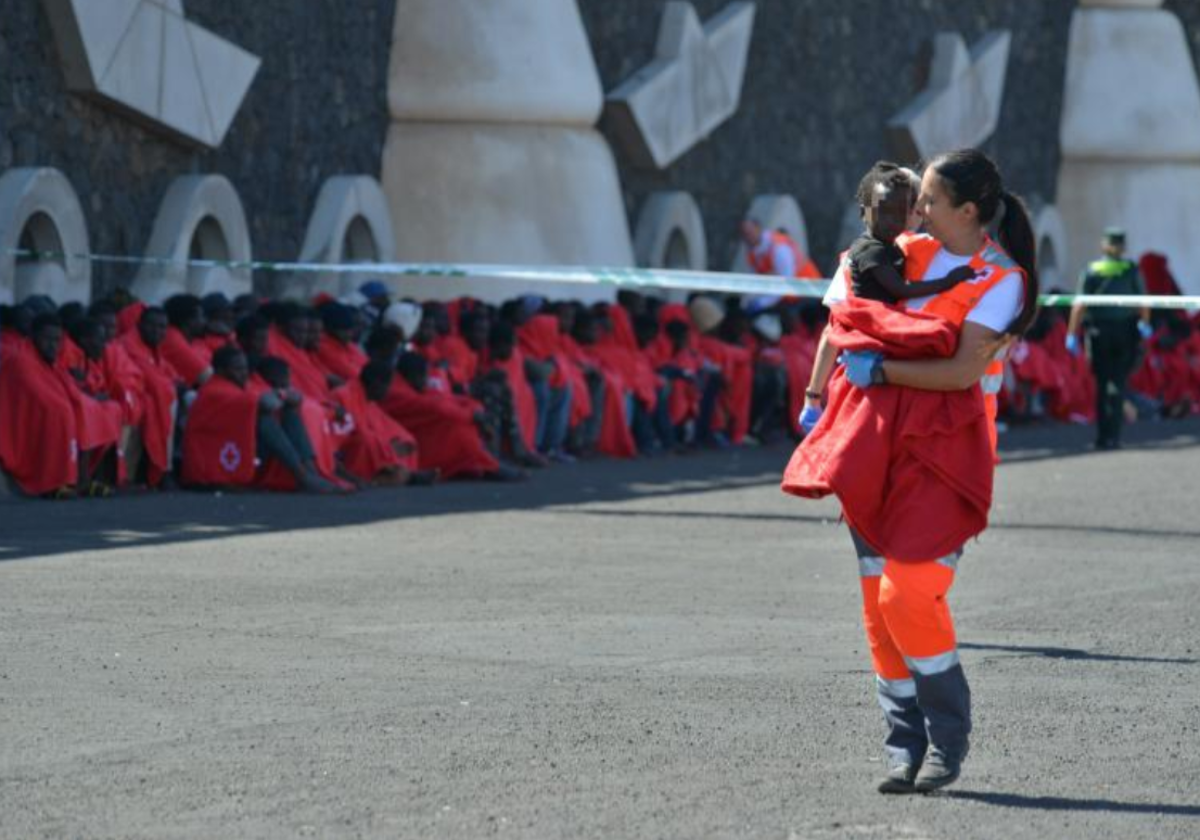 Un miembro de Cruz Roja atiende a un bebé llegado en cayuco a La Restinga, El Hierro, el pasado sábado