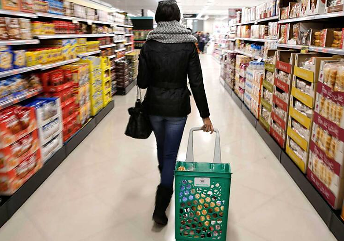 Una clienta hace la compra en un supermercado en foto de archivo