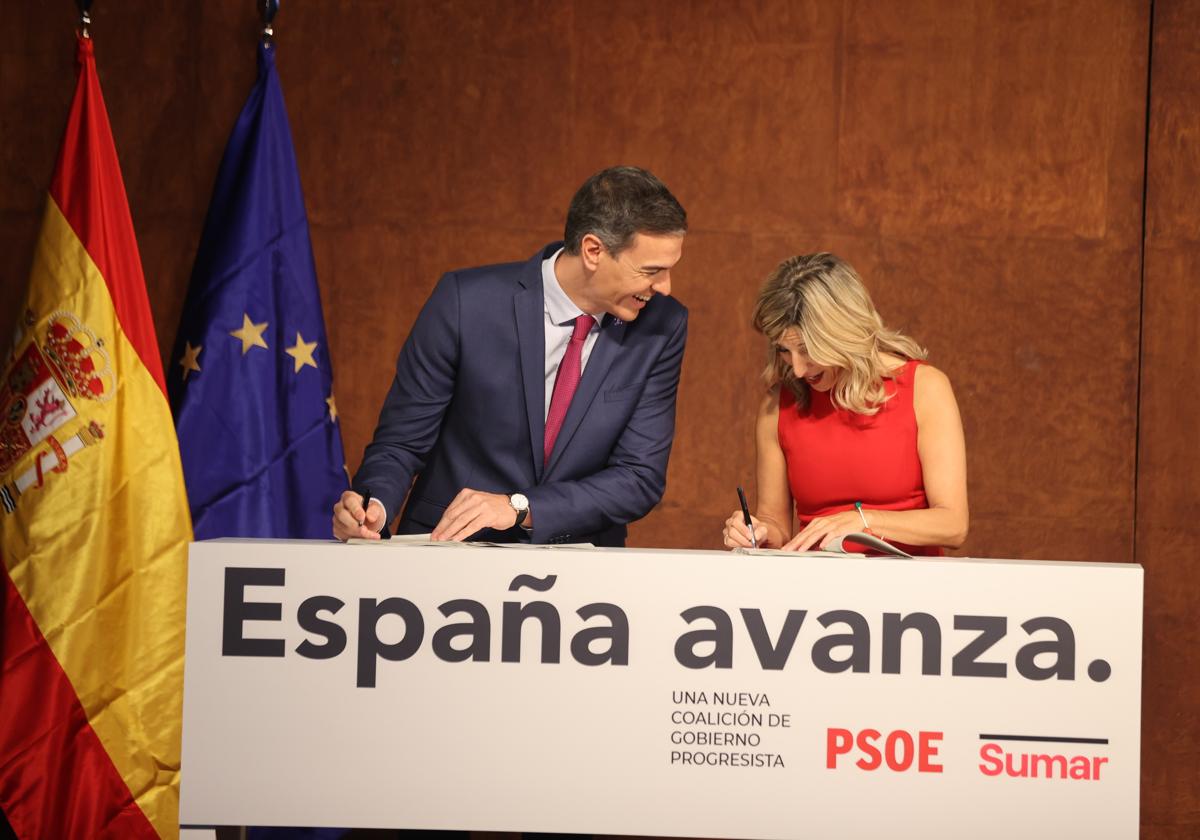 Pedro Sánchez y Yolanda Díaz firmando el acuerdo del Gobierno de coalición