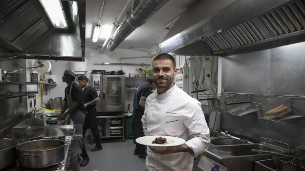 Juanjo Rodríguez posa con un plato de rabo de toro en la cocina de Bodegas Campos