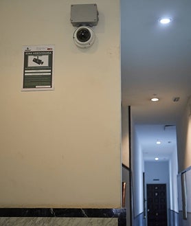 Imagen secundaria 2 - Cartel para evitar que entren los drogodependientes en un edificio en el que hay un narcopiso; puerta de la vivienda del traficante, forzada; y cámaras en las zonas comunes de otro bloque con un narcopiso para disuadir a los adictos