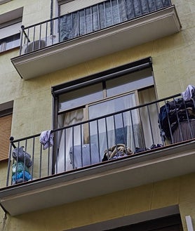 Imagen secundaria 2 - La Policía Nacional patrulla la calle del Amparo, donde los vecinos han instalado banderas amarillas contra la degradación; y el balcón de uno de los narcopisos que sigue activo pese a ser desmantelado en dos ocasiones