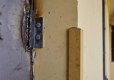 Imagen secundaria 1 - Cartel para evitar que entren los drogodependientes en un edificio en el que hay un narcopiso; puerta de la vivienda del traficante, forzada; y cámaras en las zonas comunes de otro bloque con un narcopiso para disuadir a los adictos