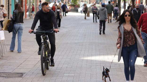 Un joven circulando en bicicelta por la calle Cruz Conde