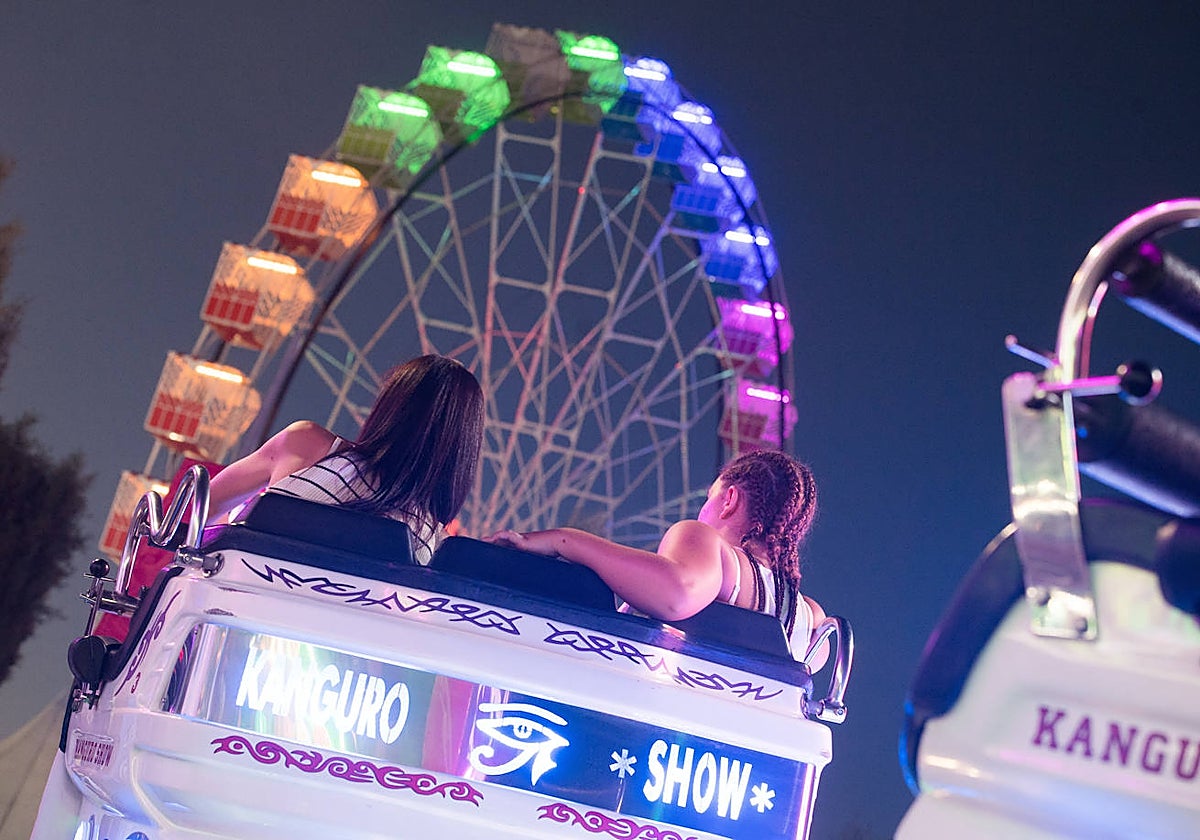 Dos chicas disfrutan de una atracción de feria en una imagen de archivo