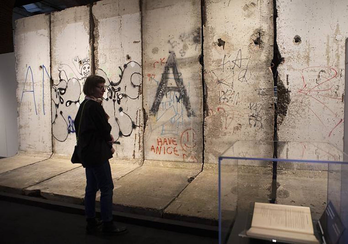 Una visitante de la muestra observa el fragmento del Muro de Berlín en la exposición de la Fundacón Canal