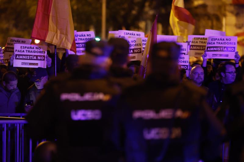 Varias personas muestran pancartas durante una nueva manifestación convocada contra la amnistía este jueves, en la calle Ferraz, en Madrid