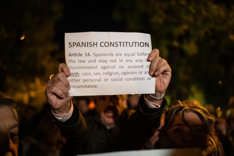 Un hombre con un cartel sobre la constitución española durante una manifestación contra la amnistía frente al Parlamento Europeo