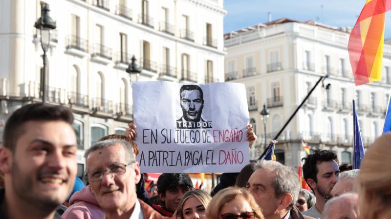 Manifestantes en la Puerta del Sol, Madrid, sujetan pancartas en contra de Pedro Sánchez. Asistentes a las protestas en Madrid: medio millón, según el Partido Popular