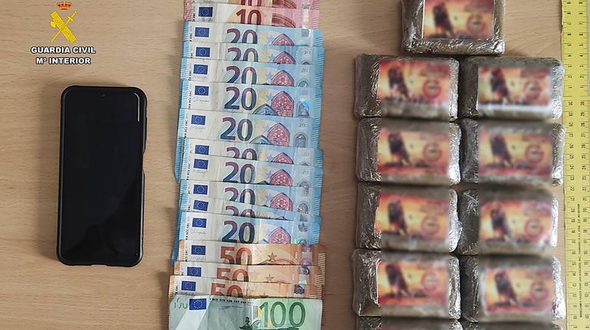 Imagen de los once paquetes de hachís junto al dinero y el móvil incautados