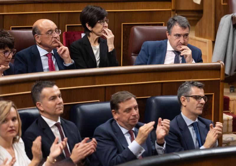Aplausos de los ministros del Gobierno, mientras el portavoz del PNV en el Congreso, Aitor Esteban, y otros diputados del partido permanecen con un gesto serio