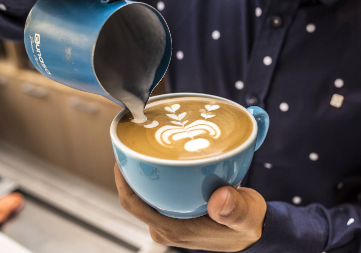 Imagen de archivo de un camarero preparando un café con leche