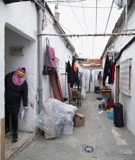 Imagen secundaria 2 - Exterior de Peironcely, 10, con puertas tapiadas que decoran grafitis con imágenes de Robert Capa; Loubma, una de las antiguas inquilinas que fue realojada, e interior de la finca, en 2021, cuando no se había hecho el realojo