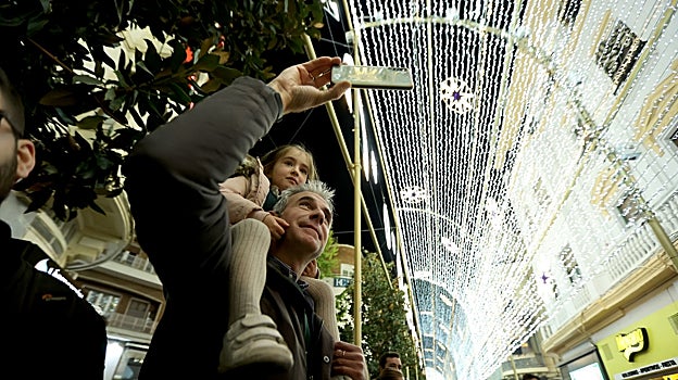 Un padre y su hija contemplan el espectáculo de luz navideña en la calle Cruz Conde el pasado año