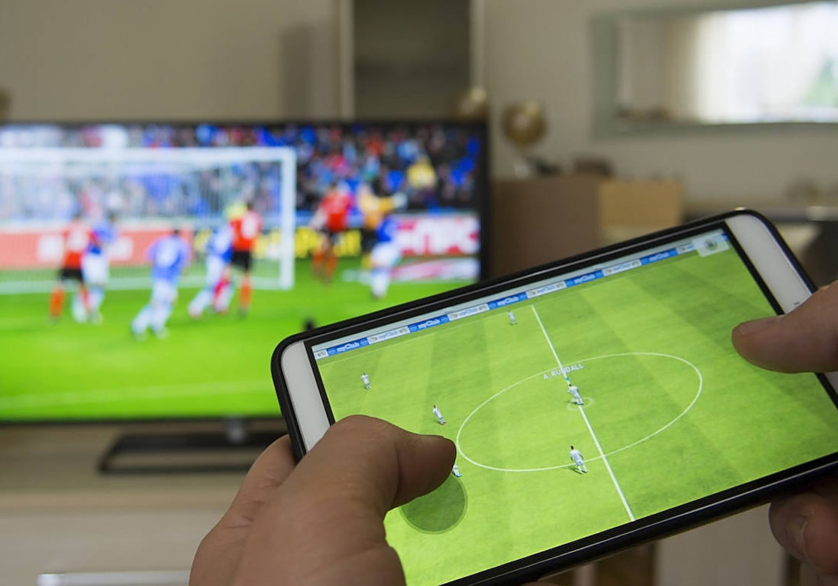 Imagen de un usuario visualizando contenidos en su teléfono móvil