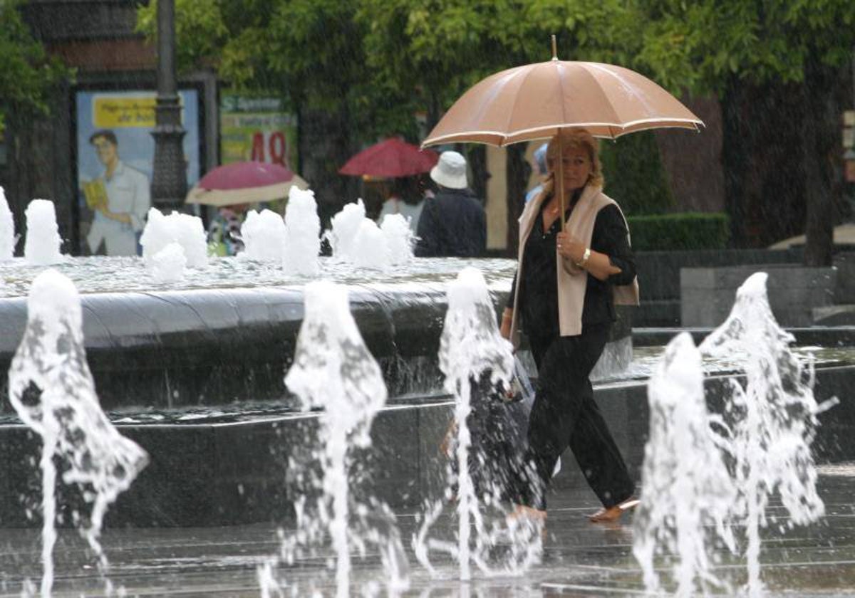 Una señora pasea por el Bulevar Gran Capitán de Córdoba un día de lluvia