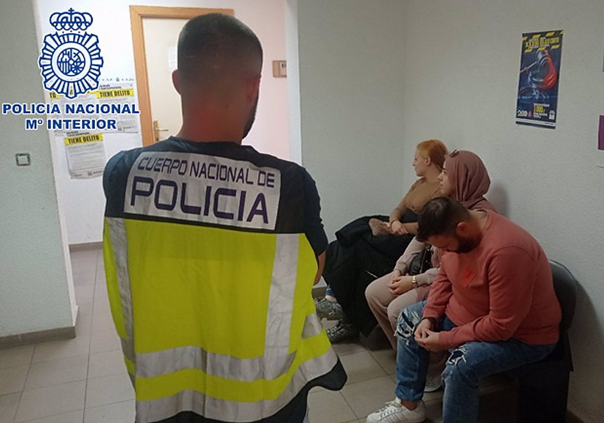 Un agente, con algunos de los detenidos