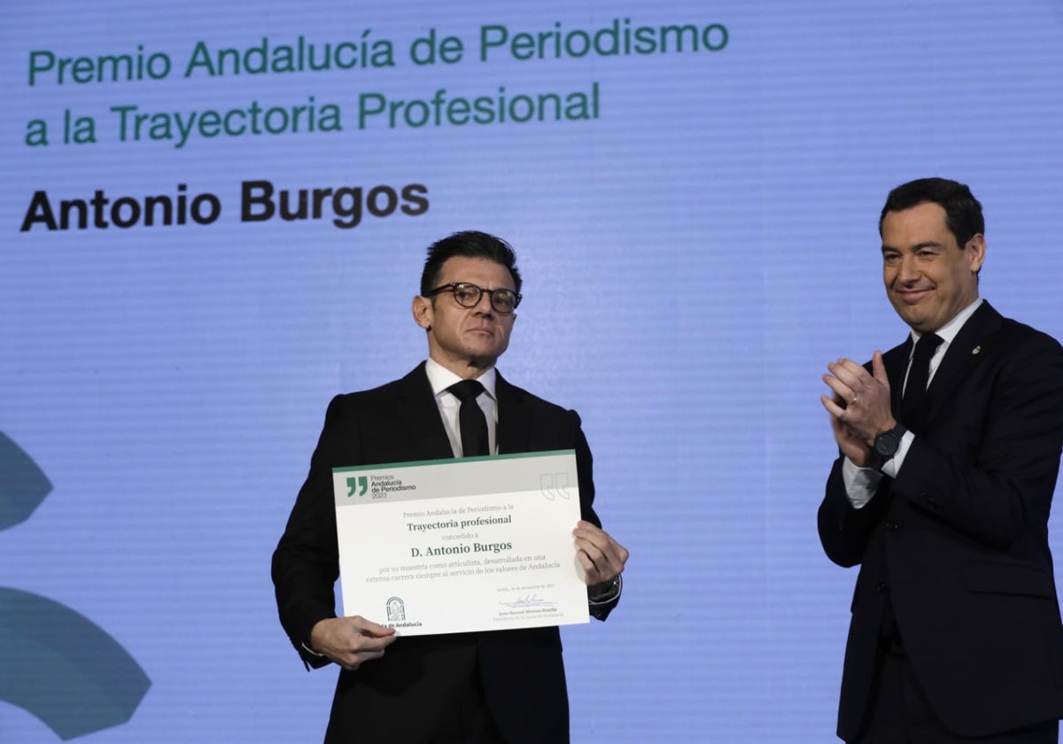 Fernando Burgos, hijo de Antonio Burgos, recoge el premio de manos de Juanma Moreno