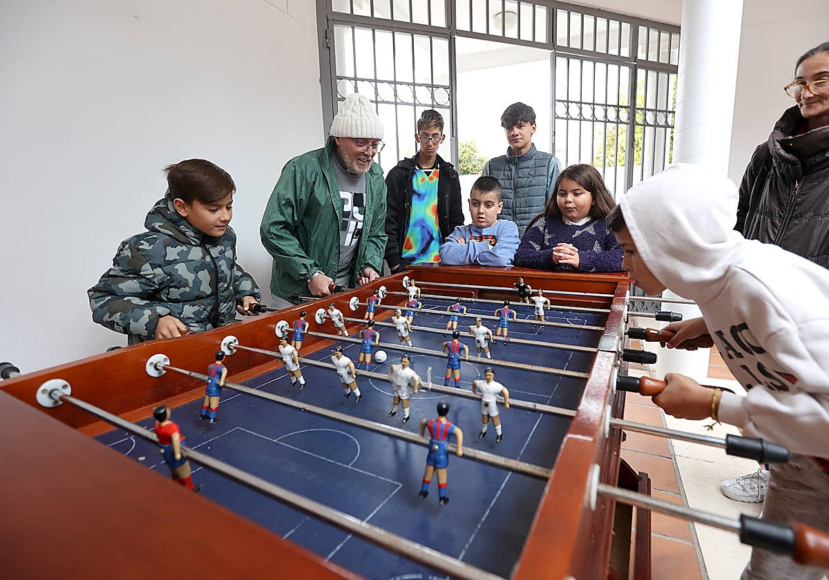 Miguel Pozo juega al futbolín con niños en La Puerta Verde