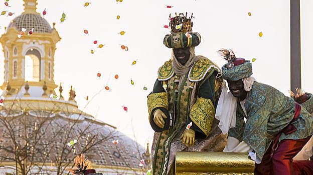 El rey Baltasar, vestido de torero, reparte caramelos con un paje en Sevilla