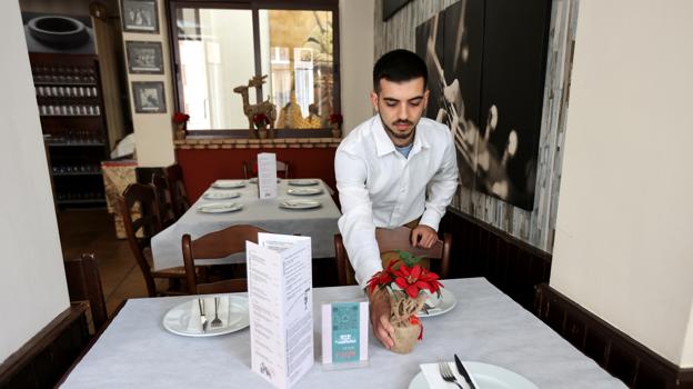 Un camarero prepara una mesa durante la Navidad en la taberna La Montillana