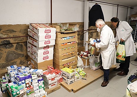 Imagen secundaria 1 - Voluntarios de 'Socorro de los Pobres' (1). Almacén con alimentos (2). Una familia haciendo recogiendo juguetes y alimentos (3)