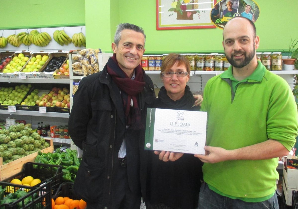 Jesús Reina (primero por la izquierda) junto a dos comerciantes de un mercado municipal de Córdoba