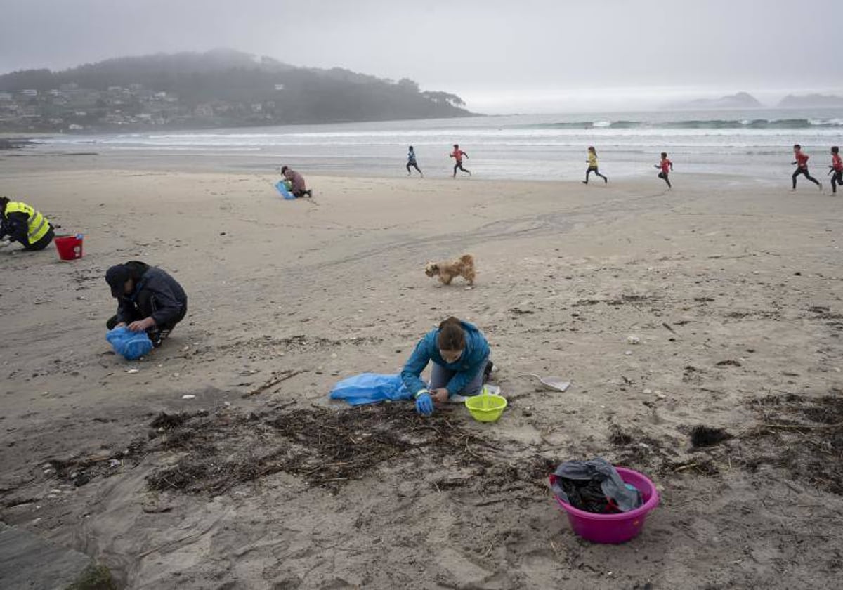 Limpieza de voluntarios de la playa de Patos, en Nigrán (Pontevedra), este lunes, organizada por este ayuntamiento