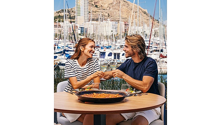 Una pareja degusta un arroz en la zona portuaria.