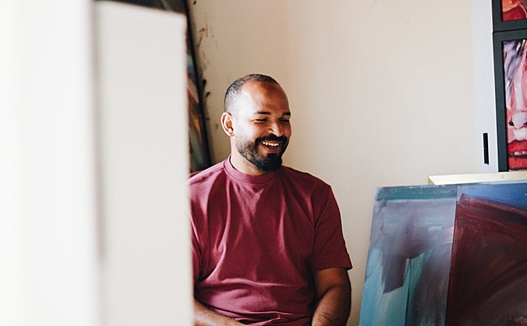 Imagen principal - Mohammed cuenta su historia frente a uno de sus cuadros Med Art en el talle