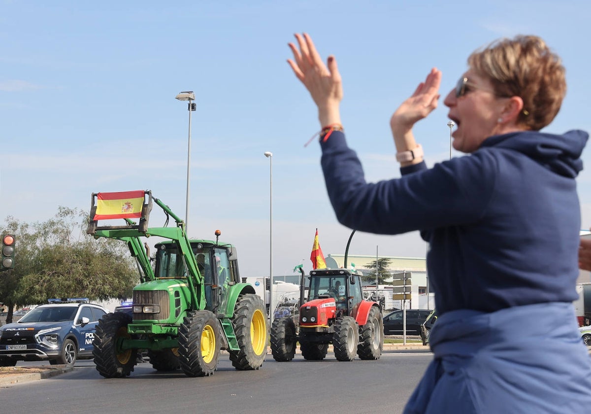 Una mujer aplaude a los tractores que llegan para la concentración