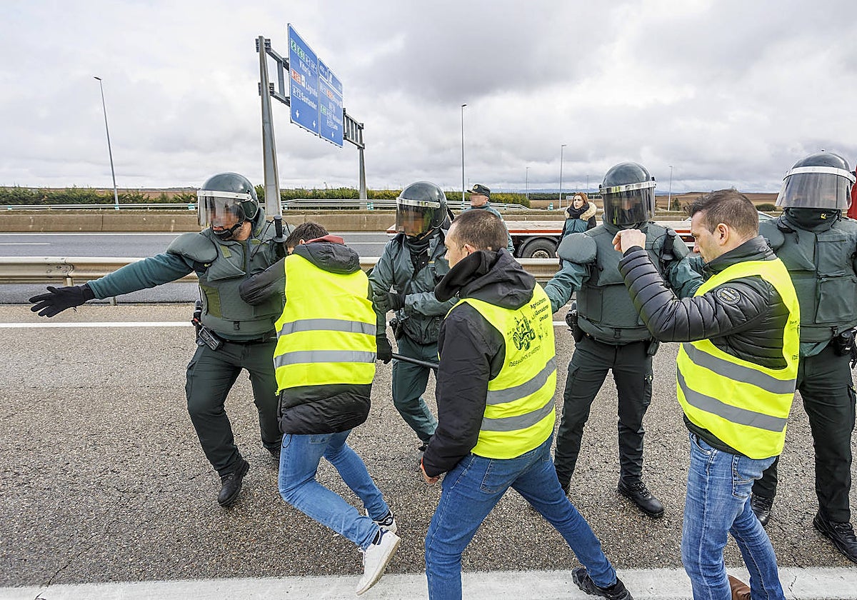 Agricultores burgaleses se enfrentan a agentes antidisturbios tras cortar la A1 en la entrada de Burgos capital este viernes