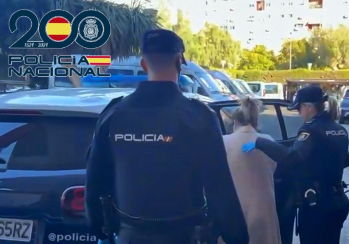 Dos agentes de Policía introducen a la detenida en el coche patrulla.