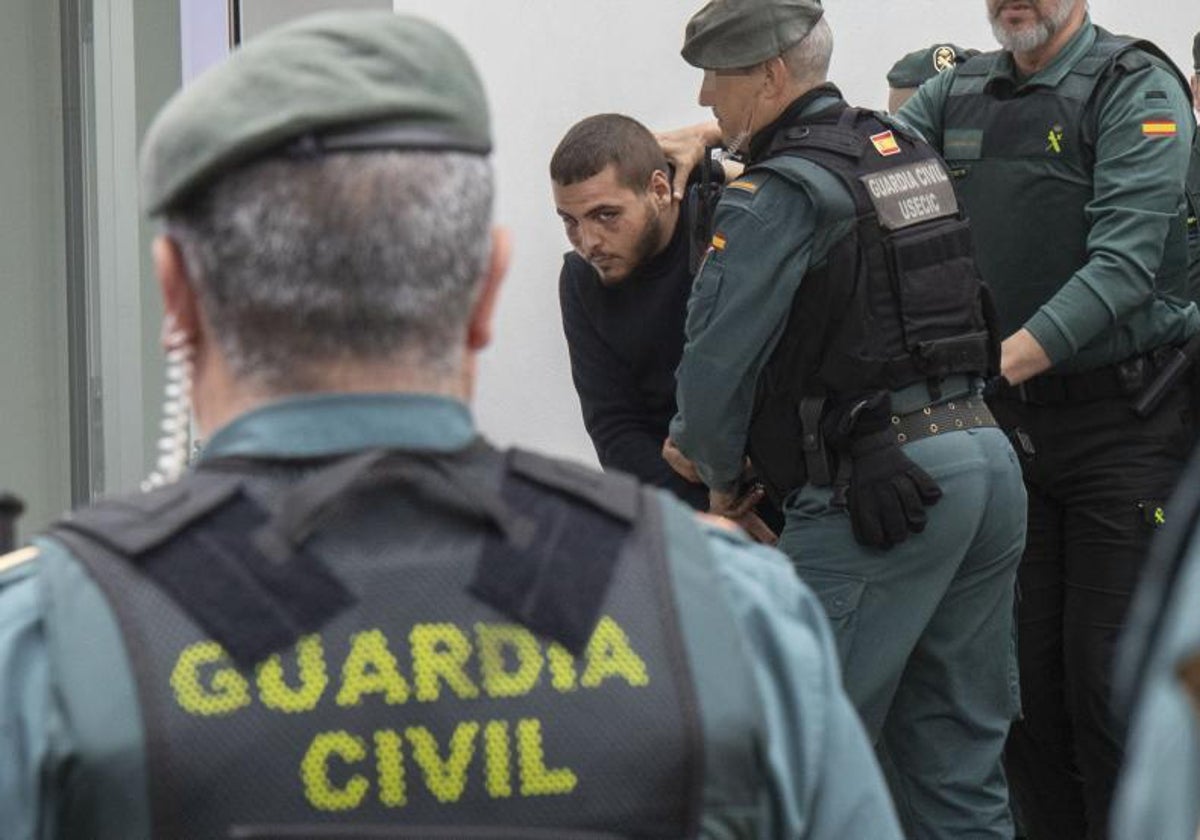 Agentes de la Guardia Civil trasladan a los juzgados de Barbate (Cádiz) a uno de los ocho detenidos por la muerte de dos guardias civiles