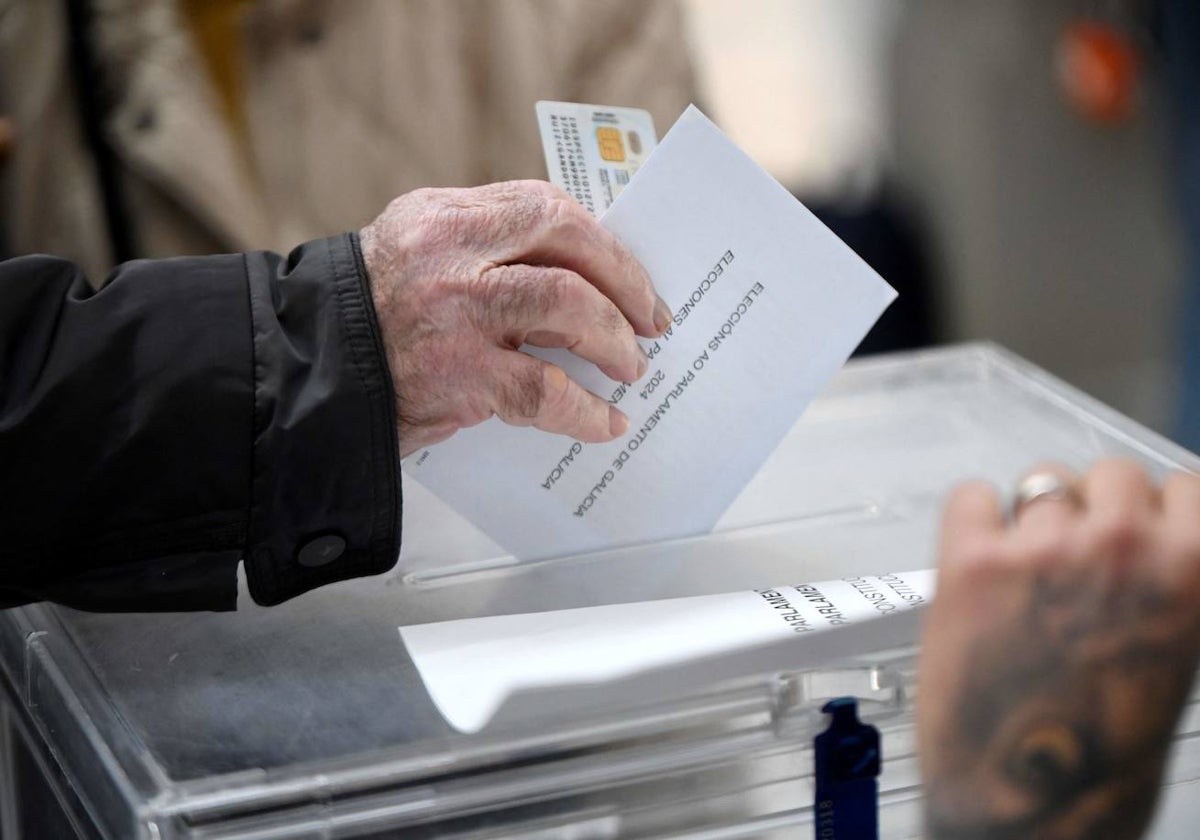 Una persona deposita su papeleta en un colegio electoral de Pontevedra