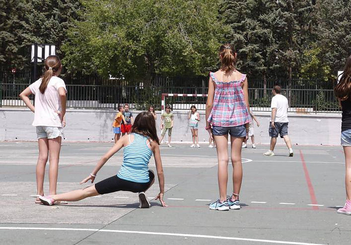 Alumnos realizando actividades deportivas en el patio de un centro escolar