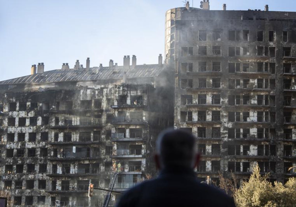 Un hombre observa la estructura del edificio incendiado en Valencia