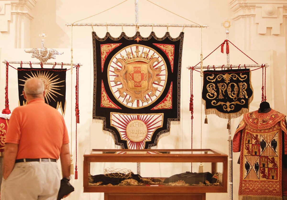 La antigua bandera, en el centro, durante la exposición de la hermandad en San Felipe Neri, en 2014