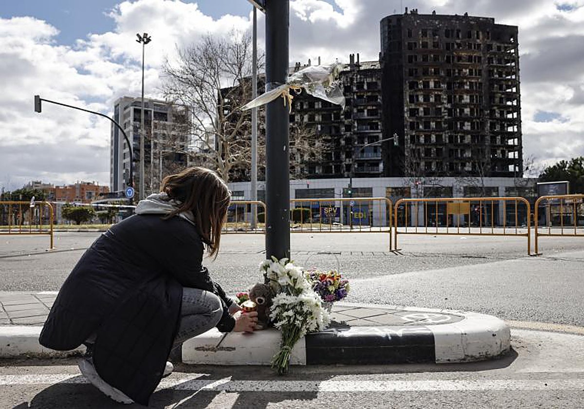Ramos de flores delante del edificio calcinado recuerdan a las victimas