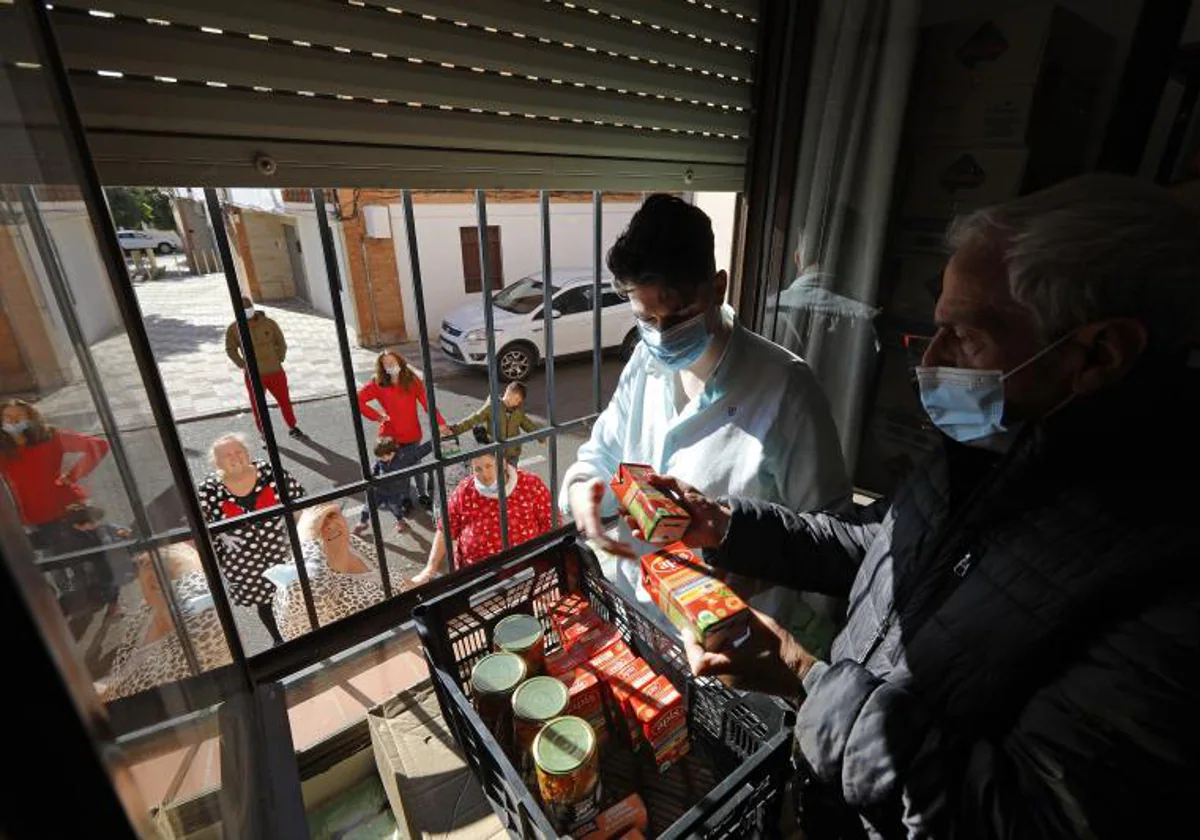 Voluntarios de Cáritas reparten de alimentos básicos en un barrio de Córdoba