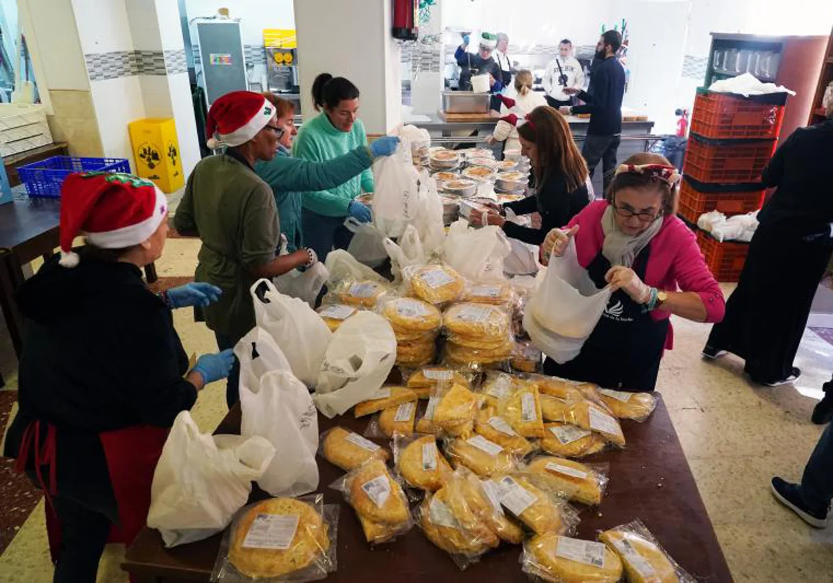 Voluntarios reparten menús navideños a personas sin recursos en la mañana previa a Nochebuena del año pasado en Málaga