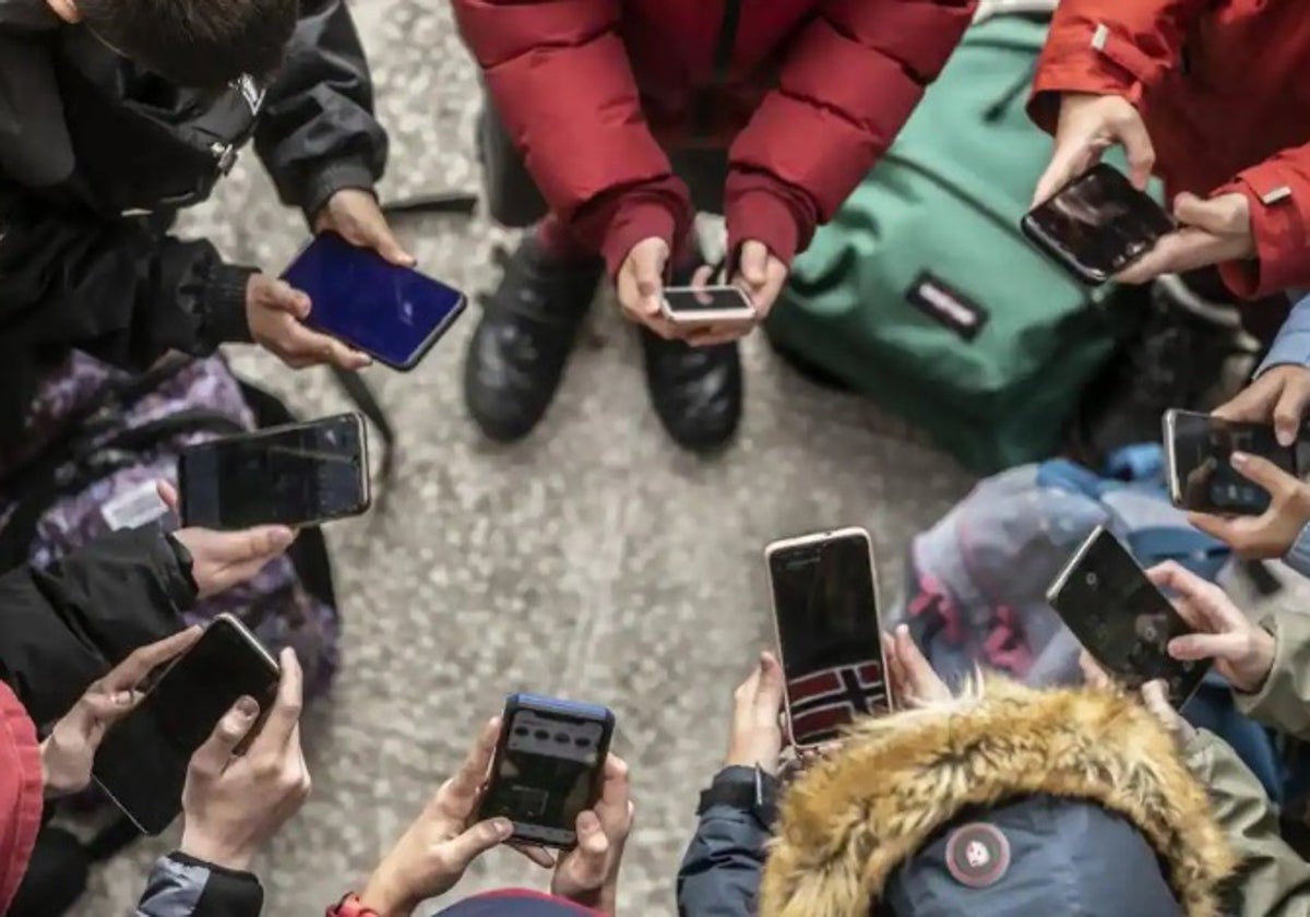 Varios jóvenes con su teléfonos móviles