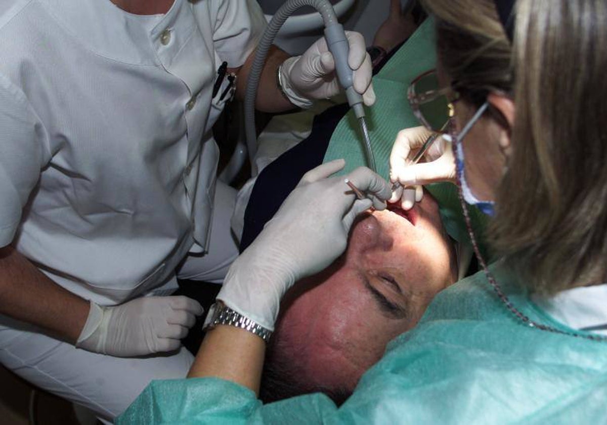 Una persona, tratada por profesionales de la salud bucodental