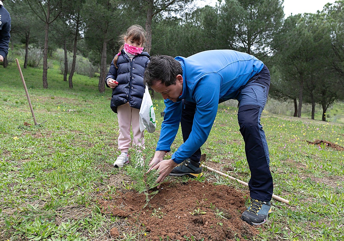 El alcalde, Carlos Velázquez, con su hija Sofía, plantando un árbol