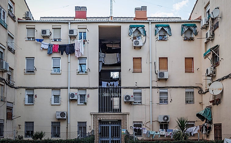 Imagen principal - La fachada de uno de los bloques de la Colonia Experimental de Villaverde. Los patios interiores, sin apenas luz natural, sirven de tendedero y las humedades campan por todas las paredes. 