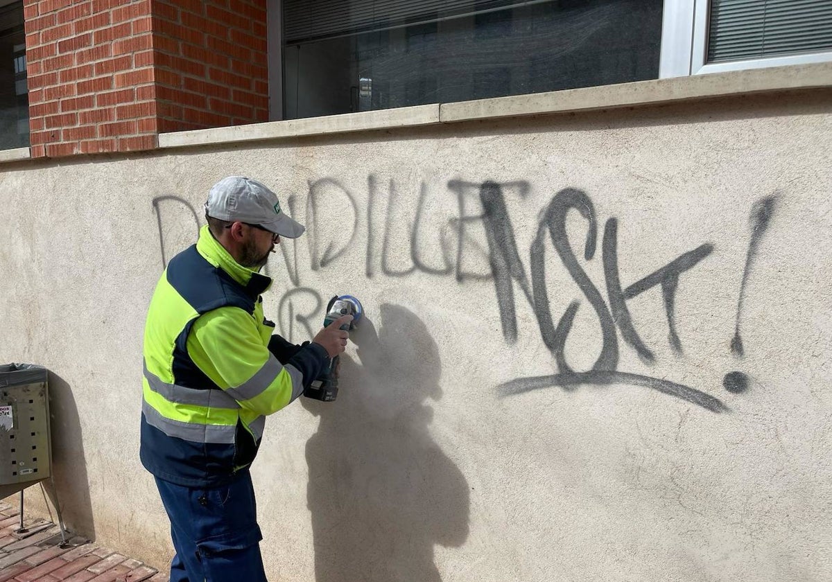 Un operario limpiando las pintadas con las que ha amanecido el Edificio Administrativo del Ayuntamiento de Benavente