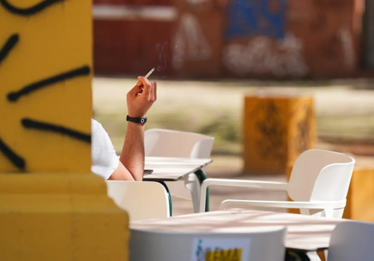 Una joven fumando en una terraza en Sevilla