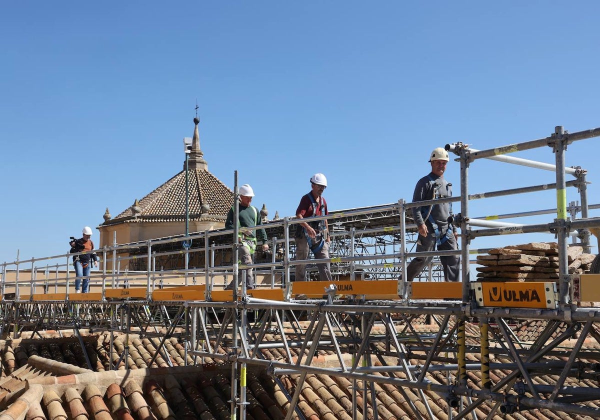 Obreros en los andamios preparados para las obras de la maqsura