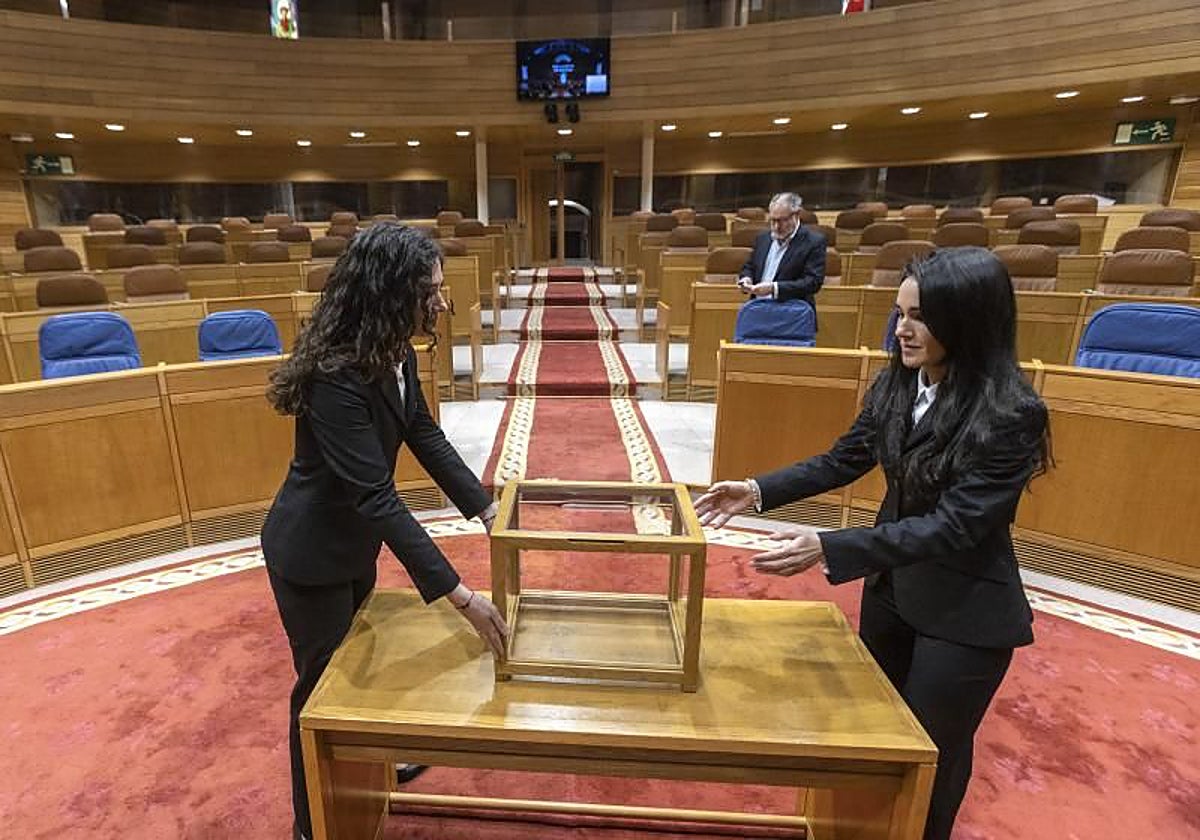 Dos ujieres se aseguran de que todo esté listo en el hemiciclo, el pasado viernes