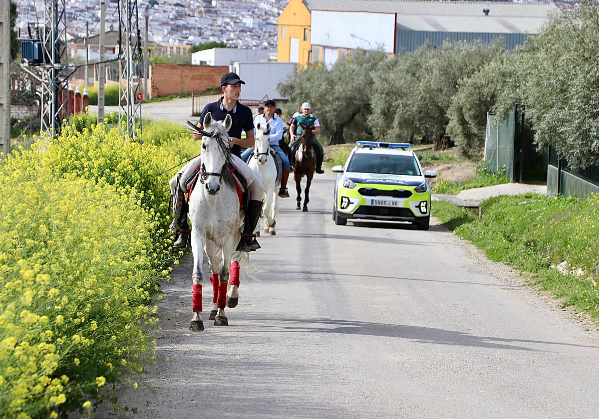 Caballistas y un coche de la Policía Local de Lucena por un camino de los alrededores este domingo